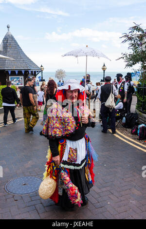 England, Broadstairs folk Woche. Die 'Idiot' aus dem Molton Morris Seite, aus Northamptonshire, für Bild posiert. Trägt ein Kleid mit viel Zubehör, Helle rote Perücke, und halten einen weißen parsole. Stockfoto