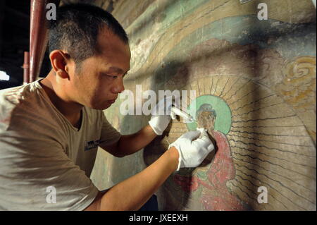 Zhengding, Hebei Provinz Chinas. 15 Aug, 2017. Ein Experte stellt ein altes Wandbild an Longxing Tempel in Zhengding, im Norden der chinesischen Provinz Hebei, 15 August, 2017. Die Restaurierung und Erhaltung der Werke des Buddhistischen Wandmalereien von der Ming Dynastie (1368-1644), belegen 400 Quadratmeter im Gange sind. Credit: Chen Qibao/Xinhua/Alamy leben Nachrichten Stockfoto