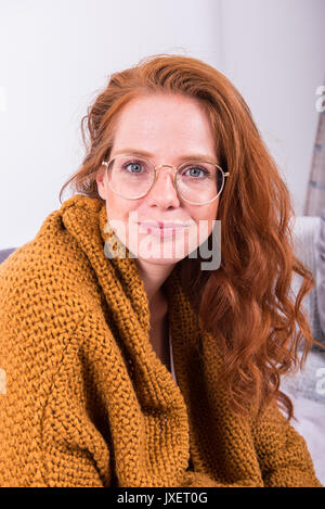 Portrait schöne rothaarige Frau in orange Strickjacke Stockfoto