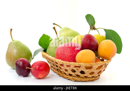 Obst Zusammensetzung - rattan Holz- korb mit ganz reife Früchte - Birnen, Pflaumen, Aprikosen und Äpfeln auf weißem Hintergrund Stockfoto