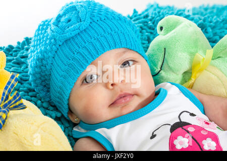 Vier Monate altes Baby Mädchen trägt eine blaue Kappe Stockfoto