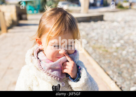 Süße kleine Kleinkind Baby Mädchen ihre Nase bohren. Stockfoto