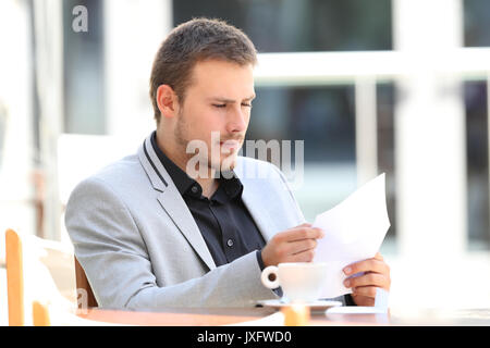 Ernsthafte Executive Brief lesen in einem Café sitzen Stockfoto