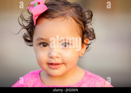 Baby Mädchen gekleidet in Rosa mit Blick auf die Kamera Stockfoto