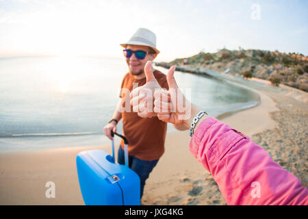 Sommer Urlaub und Ferien - Mann und Frau, Daumen oben am Strand. Stockfoto