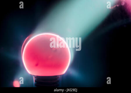 Lit Tesla Coil closeup, mit blauen elektrische Strahlen, Rot, Pink und Lila, schwarzer Hintergrund Stockfoto