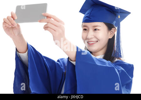 Die Studierenden tragen Bachelor Kleidung mit einem Handy Kamera Stockfoto