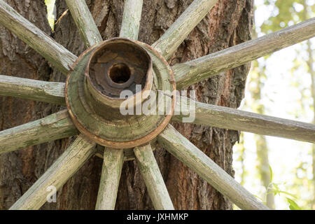 Nahaufnahme von hölzernen Wagen Rad lehnte sich an der Wand Stockfoto