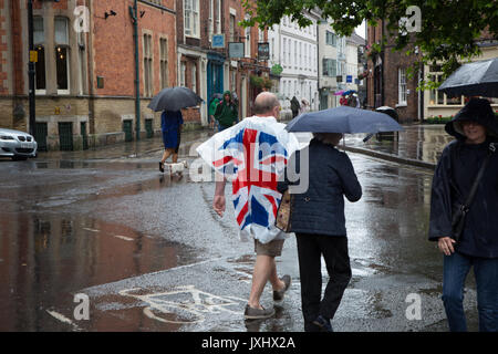 Sehr regnerischen Tag im Zentrum von York, Sonnenschirme und einen Mann, der in einer Union Flag anorak Poncho Stockfoto