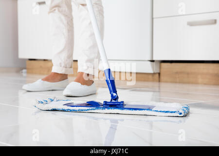 Reinigung Frau wischen den Boden in der Küche zu Hause. Stockfoto