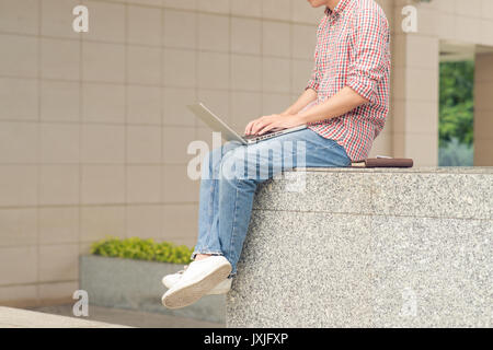 Zugeschnittenes Bild des Geschäftsmanns, der außerhalb der Gebäude Stockfoto