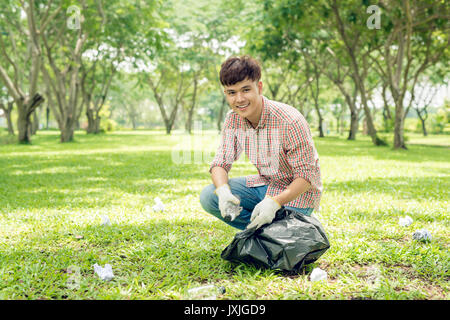 Jungen asiatischen Mann mit schwarzen Müllsack und Plastik Hausmüll in Es Stockfoto