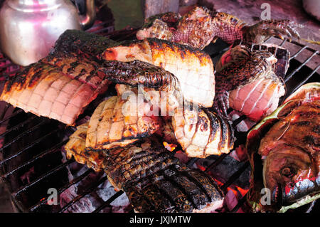 Südamerika, gebratenes Fleisch aus dem Krokodil auf dem Markt in der Großstadt in Amazonien Iquitos, Peru Stockfoto