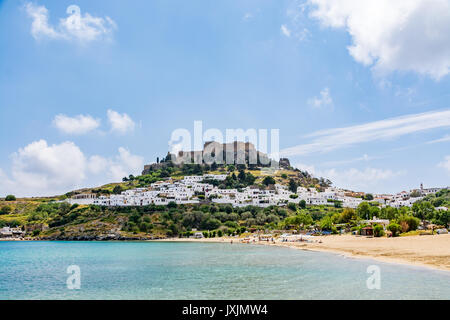 Blick auf Lindos Stadt, Schloss und Megali Paralia Strand an einem schönen Tag, Insel Rhodos, Griechenland Stockfoto