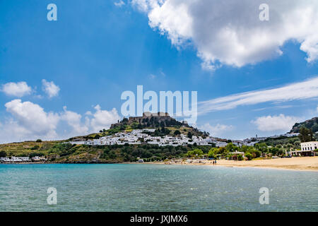 Blick auf Lindos Stadt, Schloss und Megali Paralia Strand an einem schönen Tag, Insel Rhodos, Griechenland Stockfoto