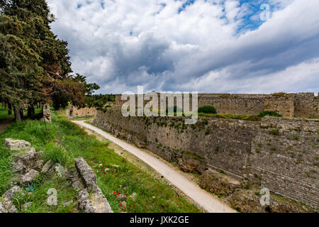 Die mittelalterlichen Mauern von Rhodos und Graben unter Moody bewölkter Himmel, Insel Rhodos, Griechenland Stockfoto