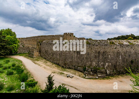 Die mittelalterlichen Mauern von Rhodos und Graben unter Moody bewölkter Himmel, Insel Rhodos, Griechenland Stockfoto