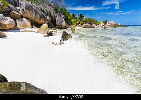 Einen kleinen weißen Strand in der Nähe von Anse Source D'Argent auf La Digue, Seychellen mit Felsen und seichtem Wasser Stockfoto
