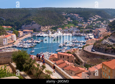 Luftaufnahme von Bonifacio Hafen mit Häusern, kurvigen Straßen und grünen Hügeln umgeben, Korsika, Frankreich Stockfoto
