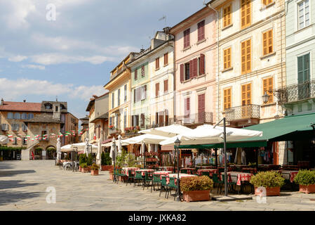 Malerischen Gebäuden und Cafés im Freien auf Motta Marktplatz im historischen, touristisches Dorf, Schuß auf hellen Sommertag in Orta San Giulio, Novara, Cusio, Stockfoto