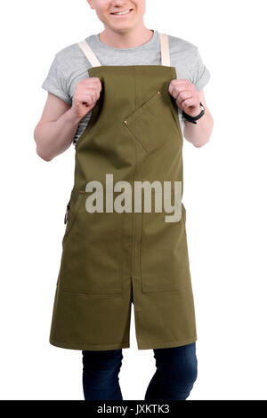 Junge Koch oder Kellner posiert, tragen, Schürze und grauen T-Shirt auf weißem Hintergrund. Barista Café Kaffee uniform. Stockfoto