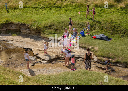 Touristen in einem Bach an Hutton le Hole Village, North York Moors, Yorkshire, England, Großbritannien Stockfoto