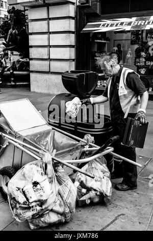 Ein Rat Arbeiter sammelt Müll von einem Lagerplatz, Piccadilly Circus, London, UK Stockfoto