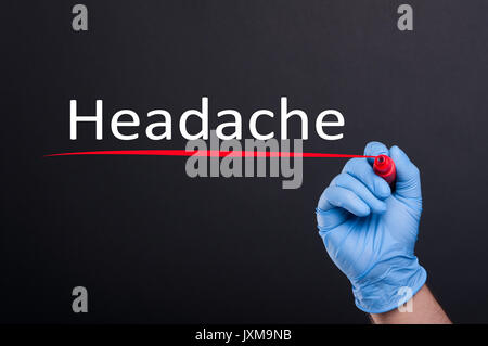 Handschriftliche Beschriftung Kopfschmerzen mit Marker in Nahaufnahme auf dunklem Hintergrund Stockfoto
