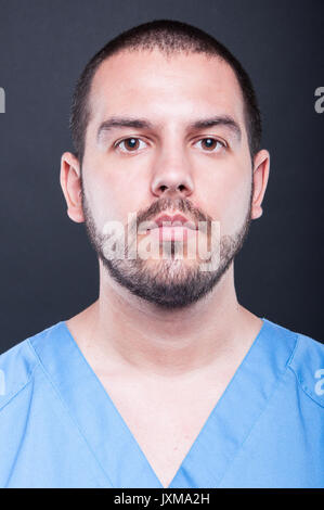 Porträt der jungen attraktiven Männliche Krankenschwester auf schwarzem Hintergrund posiert Stockfoto