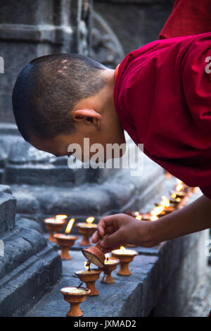 Junger buddhistischer Mönch Butterlampen bei Swayambhunath Stupa, auch als der Affe Tempel, in Kathmandu, Nepal bekannt. Stockfoto