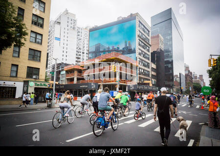 Fahrräder und Fußgänger auf die Straße, vorbei an der Entwicklung im East Village am Samstag, 12. August 2017 Für die jährliche New York Sommer Straßen Ereignis. 6,9 Meilen von Manhattan Straßen geräumt wurden von 7 Uhr bis 1 Uhr, erstreckt sich von der Brooklyn Bridge zu East 72nd Street und Tausende von Menschen kamen zu Fuß, mit dem Fahrrad und sich in den Aktivitäten, die auf der Rest waren die Haltestellen auf dem Weg. (© Richard B. Levine) Stockfoto