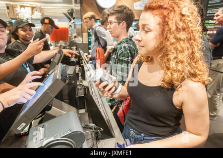 Scharen von Hungernden burger Liebhaber und durstigen Biertrinkern in Scharen in die Shake Shack in der Penn Station in New York am Montag, 14. August 2017 Für die Happy Hour Debüt party von Blue's Point Brauerei Rufumleitung' Bier. Als Reaktion auf die 'Summer der Hölle', die Long Island Railroad Passagiere wegen Wartung track Arbeit Blue Point Brauerei werden erstellt ihre Rufumleitung "Pilsner Bier mit der Grafik auf dem kann ein Riff auf der LIRR Abfahrtstafeln. Die ersten 100 Kunden erhalten einen kostenlosen Burger mit dem Kauf einer Rufumleitung". (© Richard B. Levine) Stockfoto