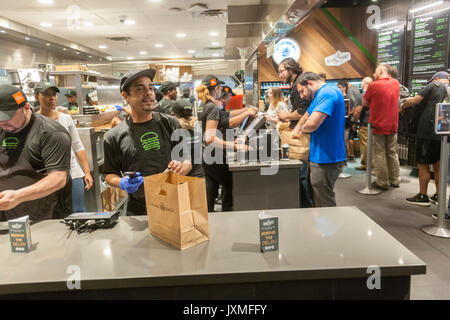 Scharen von Hungernden burger Liebhaber und durstigen Biertrinkern in Scharen in die Shake Shack in der Penn Station in New York am Montag, 14. August 2017 Für die Happy Hour Debüt party von Blue's Point Brauerei Rufumleitung' Bier. Als Reaktion auf die 'Summer der Hölle', die Long Island Railroad Passagiere wegen Wartung track Arbeit Blue Point Brauerei werden erstellt ihre Rufumleitung "Pilsner Bier mit der Grafik auf dem kann ein Riff auf der LIRR Abfahrtstafeln. Die ersten 100 Kunden erhalten einen kostenlosen Burger mit dem Kauf einer Rufumleitung". (© Richard B. Levine) Stockfoto