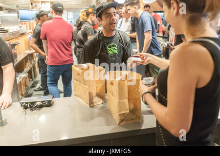 Scharen von Hungernden burger Liebhaber und durstigen Biertrinkern in Scharen in die Shake Shack in der Penn Station in New York am Montag, 14. August 2017 Für die Happy Hour Debüt party von Blue's Point Brauerei Rufumleitung' Bier. Als Reaktion auf die 'Summer der Hölle', die Long Island Railroad Passagiere wegen Wartung track Arbeit Blue Point Brauerei werden erstellt ihre Rufumleitung "Pilsner Bier mit der Grafik auf dem kann ein Riff auf der LIRR Abfahrtstafeln. Die ersten 100 Kunden erhalten einen kostenlosen Burger mit dem Kauf einer Rufumleitung". (© Richard B. Levine) Stockfoto