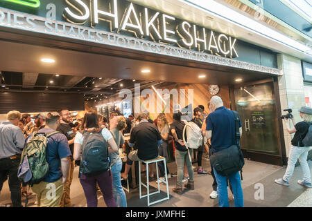 Scharen von Hungernden burger Liebhaber und durstigen Biertrinkern in Scharen in die Shake Shack in der Penn Station in New York am Montag, 14. August 2017 Für die Happy Hour Debüt party von Blue's Point Brauerei Rufumleitung' Bier. Als Reaktion auf die 'Summer der Hölle', die Long Island Railroad Passagiere wegen Wartung track Arbeit Blue Point Brauerei werden erstellt ihre Rufumleitung "Pilsner Bier mit der Grafik auf dem kann ein Riff auf der LIRR Abfahrtstafeln. Die ersten 100 Kunden erhalten einen kostenlosen Burger mit dem Kauf einer Rufumleitung". (© Richard B. Levine) Stockfoto