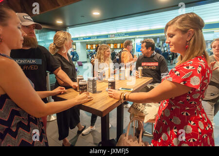 Scharen von Hungernden burger Liebhaber und durstigen Biertrinkern in Scharen in die Shake Shack in der Penn Station in New York am Montag, 14. August 2017 Für die Happy Hour Debüt party von Blue's Point Brauerei Rufumleitung' Bier. Als Reaktion auf die 'Summer der Hölle', die Long Island Railroad Passagiere wegen Wartung track Arbeit Blue Point Brauerei werden erstellt ihre Rufumleitung "Pilsner Bier mit der Grafik auf dem kann ein Riff auf der LIRR Abfahrtstafeln. Die ersten 100 Kunden erhalten einen kostenlosen Burger mit dem Kauf einer Rufumleitung". (© Richard B. Levine) Stockfoto