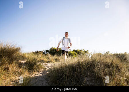 Junger Mann training, Power Walking auf Sanddünen Stockfoto