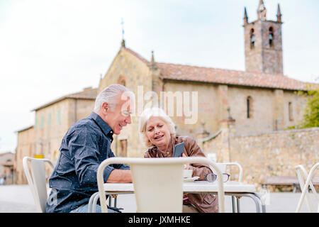 Touristische Paar an das Smartphone auf Sidewalk Cafe, Siena, Toskana, Italien Stockfoto