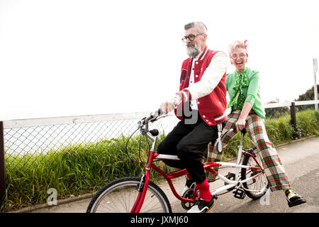 Skurrile paar Sightseeing auf tandem Fahrrad, Bournemouth, England Stockfoto