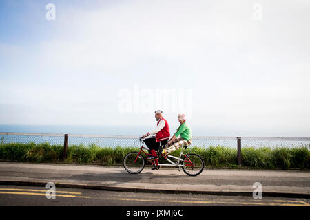 Skurrile paar Sightseeing auf tandem Fahrrad, Bournemouth, England Stockfoto