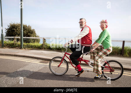 Skurrile paar Sightseeing auf tandem Fahrrad, Bournemouth, England Stockfoto