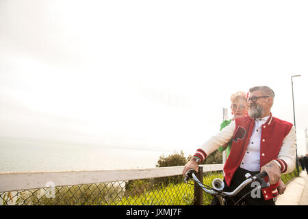 Skurrile paar Sightseeing auf tandem Fahrrad, Bournemouth, England Stockfoto