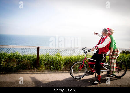 Skurrile paar Sightseeing auf tandem Fahrrad, Bournemouth, England Stockfoto