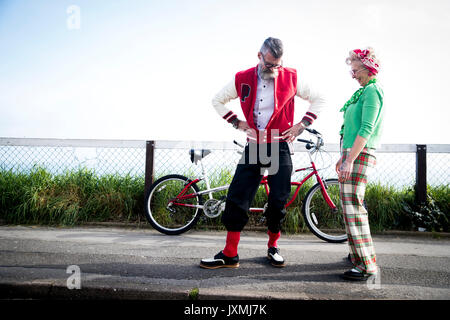 Skurrile paar Sightseeing auf tandem Fahrrad, Bournemouth, England Stockfoto