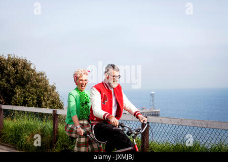 Skurrile paar Sightseeing auf tandem Fahrrad, Bournemouth, England Stockfoto