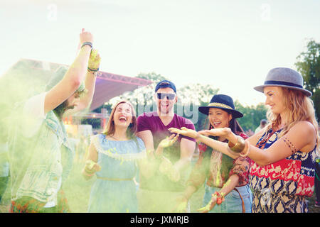 Junge Erwachsene Freunde werfen farbige Kreide Pulver und Tanzen bei Festival Stockfoto