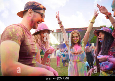 Junge Erwachsene Freunde tanzen in farbige Kreide Pulver bedeckt bei Festival Stockfoto