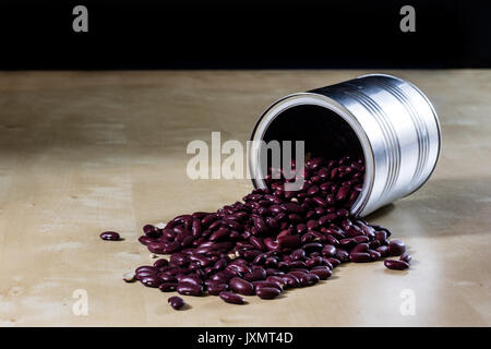 Lecker Bohnen in einem Metall Glas auf einem hölzernen Küchentisch. Schwarzen Hintergrund. Stockfoto