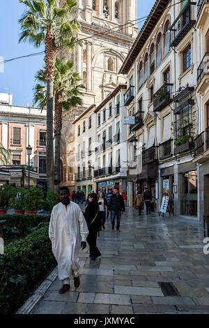 Menschen zu Fuß auf carcel baja Street und Glockenturm, schwarzer Mann in weißen Gewändern auf der Straße, Granada, Andalusien, Spanien Stockfoto