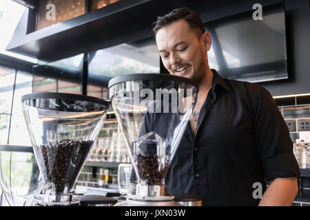 Glückliche junge Mann Vorbereitung espresso beim Arbeiten als barista in Einem Stockfoto